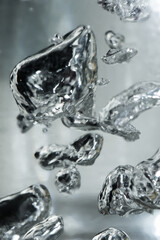 Drops and bubbles of mercury in water. Dangerous chemical element, the scientific experience.