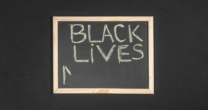 slogan black lives matter written by hand on the chalkboard. protest against racism and concept of equal rights