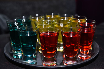 Various alcoholic shots in shot glasses in a serving tray often used for offers in the drinks industry