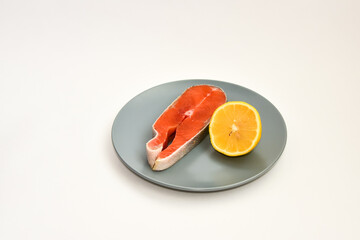 Fresh raw salmon steak with lemon slice isolated on white background