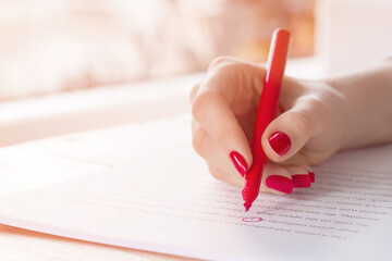 Editor or teacher hand with red pen proofreading errors in a manuscript essay