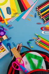 Colorful school supplies on blue background with copy space,top view of education concept.