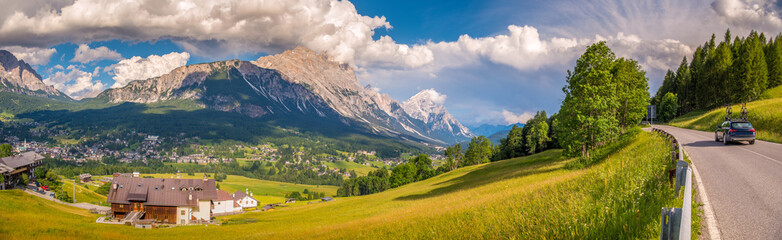 Mountains with alpine village on sunny summer day, the Dolomites Mountains, Italy
