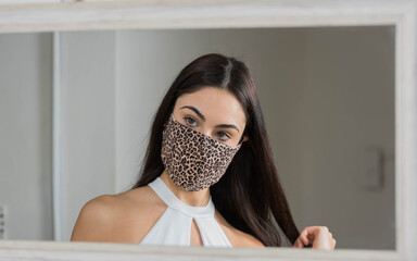 Joven mujer, preparándose frente al  espejo.