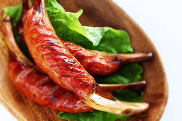 Grilled bone sausage on wooden plate with copy space
