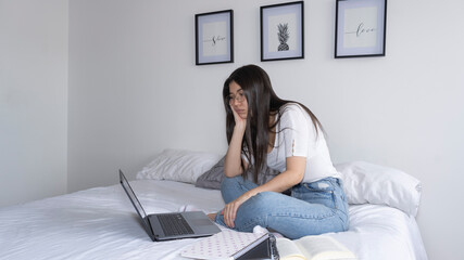 young girl with boring expression in front of the laptop.