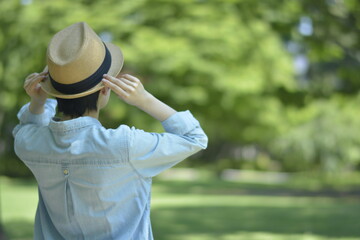 Asian young women.  like spending time in the middle of nature.   wear a hat at a rakish angle.  blurred background with copy space.