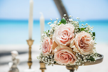 Bridal wedding fresh flowers bouquet on the sandy beach as decoration for tropical caribbean destination marriage matrimonial wedding ceremony in Dominican republic Punta Cana 