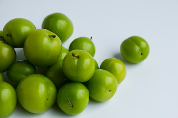 Fresh,ripe green plums on the light color surface with copy space.
