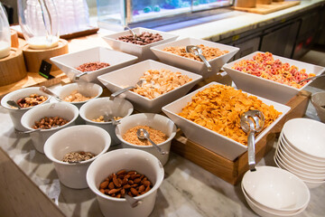 Various type of cereals and nuts toppings at the morning breakfast buffet all-you-can-eat.
