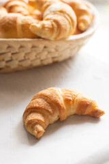 Fresh croissants on the table and in a wicker basket for Breakfast