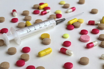 Texture of different drugs on a gray background with a syringe