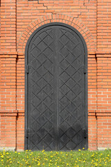 Iron gate in the form of an arch in a brick wall