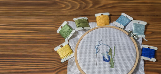 Embroidery prosees on the table with coloful threads