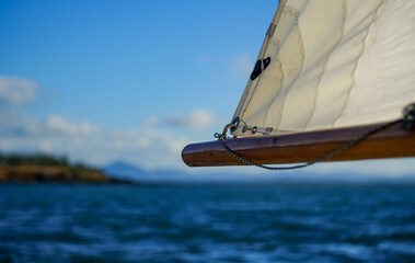 Detail of sail on small sailing boat in vast seascape between Bird Island and Turkey Beach, Queensland