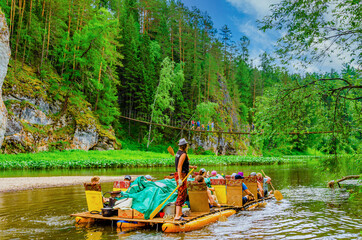Fototapeta premium People are floating on an inflatable raft on the river among the mountains.