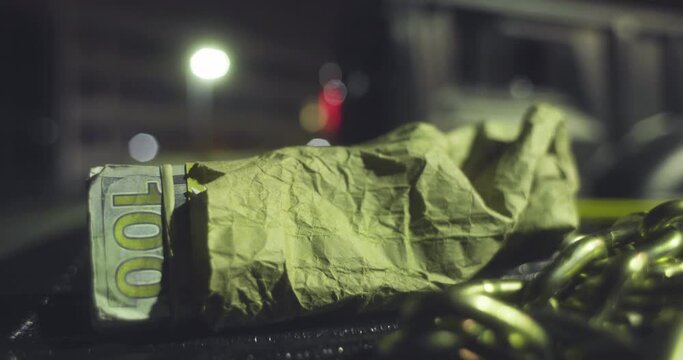 a Thief steals a bag of money from the back of a truck at night. Two men run after him.