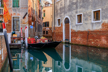 Traditional ornate venetian gondola docked in a picturesque canal in Venice, Italy