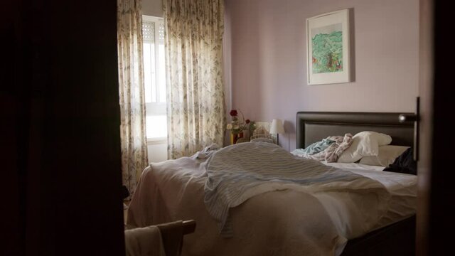 Empty comfy family bedroom interior apartment with curtains and natural light no people during the day wide shot
