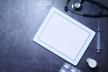 Medical Stethoscope and digital tablet on dark background 