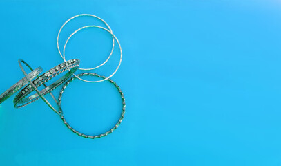    bracelets made of dark and light silver metal on a blue background, selective focus , copy space     
