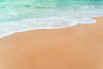 Top view of sand and water clean beach and white sand in summer with sun light blue sky and bokeh background.
