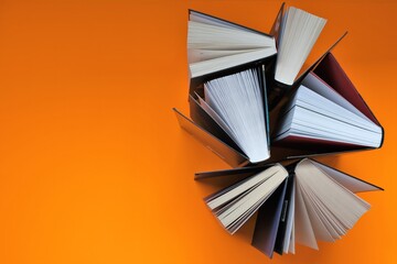 Books set on a bright orange background.Reading and education concept.books close up. Training and...