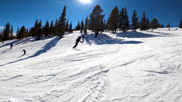 SMOOTH ACTION FOOTAGE watch a female snowboarder ride though light moguls then coming to a  short stop