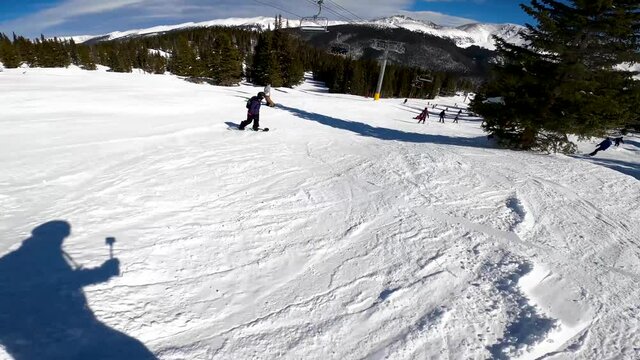 female snowboarder working her way though ski traffic at the resort in Colorado. SMOOTH ACTION FOOTAGE
