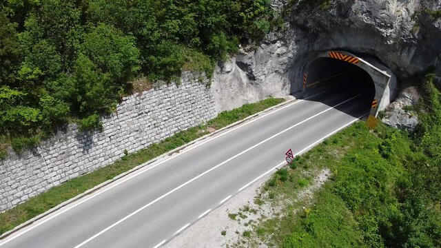 Transport truck with sand exits from tunnel on traffic road. Aerial view 
