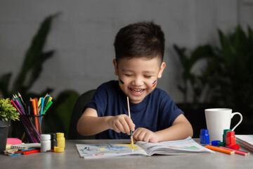 Happy little kid at the table draw with water color Learning and education of kid.