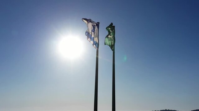 Flag of Israel and The Israel Nature and Parks Authority
flags on blue sky background and sun flare
