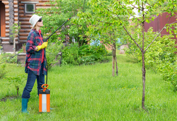 A woman sprays trees in the garden