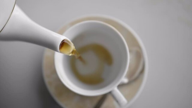 Slow motion birds eye view tea pour with soft light