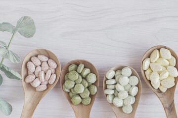 Natural cruciferous vegetables and alternative herbal tablet pills in wooden spoons, keto diet...