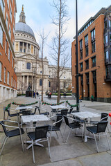 Naklejka premium View of the famous St. Paul's Cathedral behind cafe tables with Christmas decorations on a cloudy day in London, England