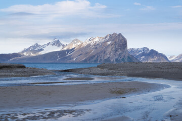 Wonderful scenic landscape over "Hornsund" on Spitsbergen. Pointy mountains and melting water streams in the foreground.