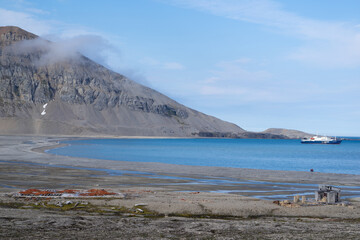 View over the fjord from "Gashamna" at "Hornsund" on Spitsbergen. Red bricks and whale bones are lying in a distance on the ground.
