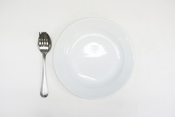 A white plate with a practice spoon placed on a white background