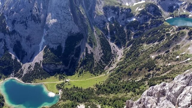 Aerial camera pan (left to right) of Mieminger mountains in Austria Tyrol with Drachensee, lodge Coburger H&uuml;tte and Seebensee. Sunny summer day with blue skys. Vantage point is peak of Sonnenspitze
