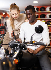Fototapeta na wymiar couple in motorcycle shop choosing new vehicle