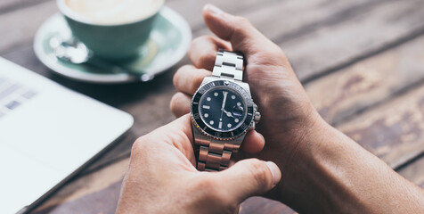 fashionable wearing stylish looking at luxury watch on hand check the time at workplace.concept for managing time organization working,punctuality,appointment