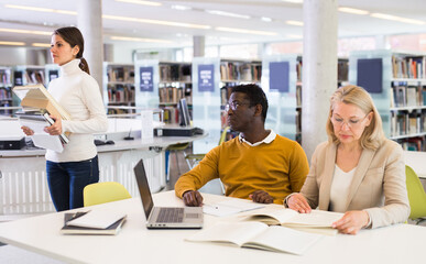 Obraz premium Professor and students communicate in the library