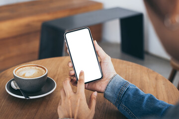 cell phone mockup image blank white screen.woman hand holding texting using mobile on desk at coffee shop.background empty space for advertise.work people contact marketing business,technology