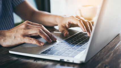 using computer.hand typing keyboard laptop online chatting search form internet while working sitting at coffee shop.concept for.technology device contact communication business people