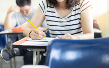 high school,university student study.hands holding pencil writing paper answer sheet.sitting lecture chair taking final exam attending in examination classroom.concept scholarship for education abroad