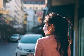 Asian adult woman tan skin wear mask on face in city