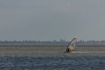 windsurfing at the lake with landscape in the background