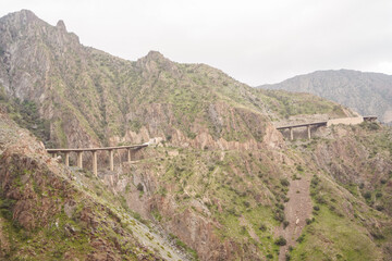 Fototapeta na wymiar steep mountain road infrastructure with bridges along steep mountain