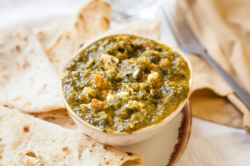 Plated indian, pakistani or bangladeshi food saag paneer with roti bread freshly cooked. Nutritious and healthy food full of flavor for vegetarian people. Asian food with negative space.